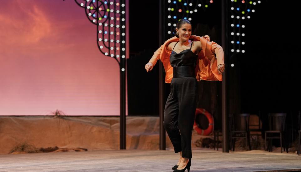 Une femme dansant, remettant sa veste rose sur sa tenue noire