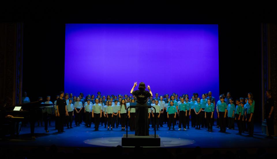 Cheffe de chant devant une chorale d'enfants