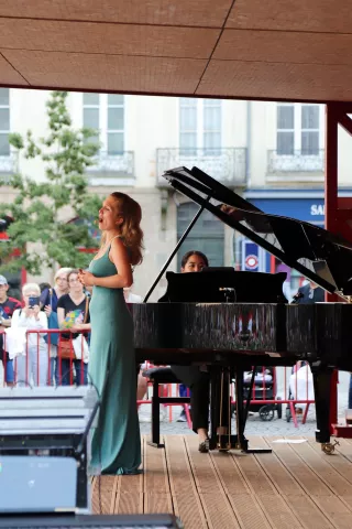 Chanteuse accompagnée d'une pianiste sur la scène d'Opéra sur transat