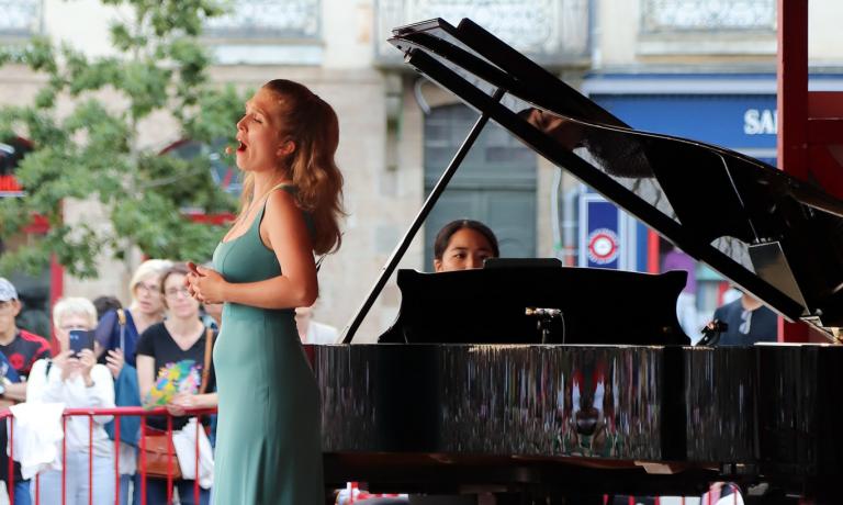Chanteuse accompagnée d'une pianiste sur la scène d'Opéra sur transat